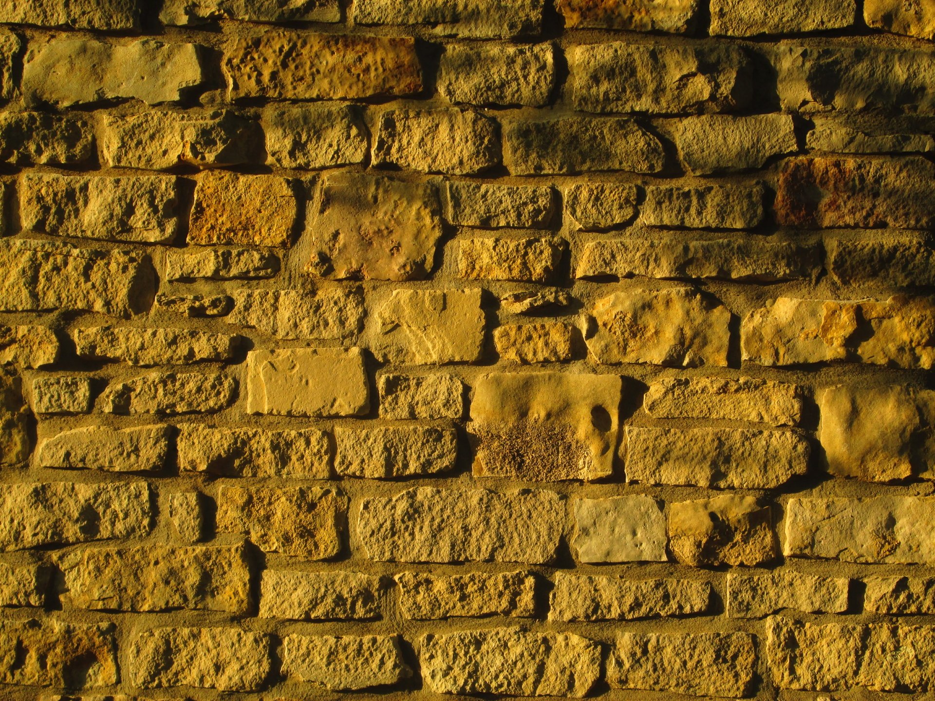 4K Ultra HD PC desktop wallpaper showing a man-made textured yellow brick wall with warm lighting and deep shadows.