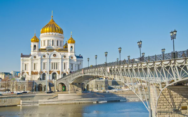 HD desktop wallpaper featuring the Cathedral of Christ the Saviour with its golden domes under a clear blue sky, viewed alongside a decorative bridge.