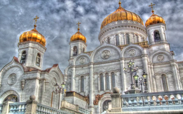 Religious view of the Cathedral of Christ the Saviour: gilded domes and ornate white facade under dramatic clouds — HD PC desktop wallpaper/background