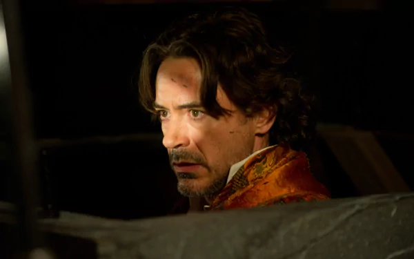 Robert Downey Jr. stars as Sherlock Holmes in Sherlock Holmes: A Game of Shadows, captured in a dramatic moment in this stunning 4K Ultra HD wallpaper.