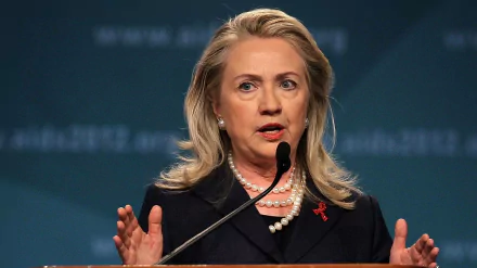 HD desktop wallpaper featuring Hillary Rodham Clinton speaking at a podium, suitable as a background.