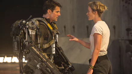 Tom Cruise and Emily Blunt share an intense moment in this scene from the movie Edge of Tomorrow, featuring futuristic combat gear in a striking 4K Ultra HD background.