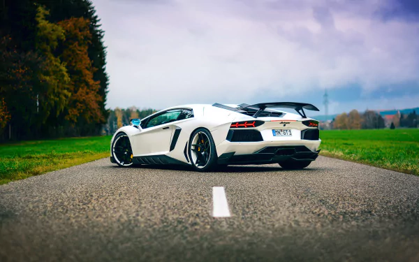 HD desktop wallpaper featuring a Lamborghini Aventador parked on a rural road, surrounded by vibrant autumn foliage.