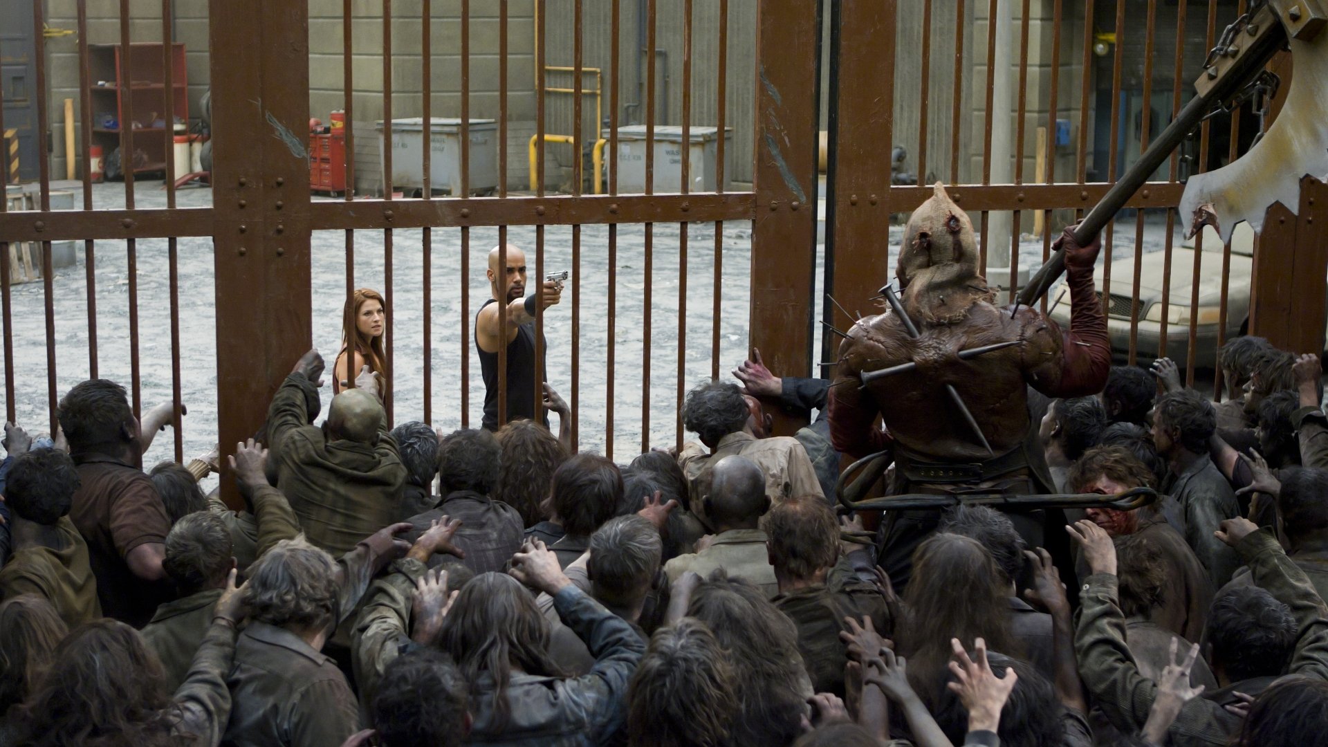 HD PC desktop wallpaper featuring a scene from the movie Resident Evil: Afterlife with characters confronting a crowd of zombies behind metal bars.