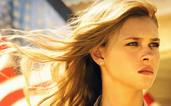 HD desktop wallpaper featuring Nicola Peltz from the movie Transformers: Age of Extinction, with an American flag in the background.