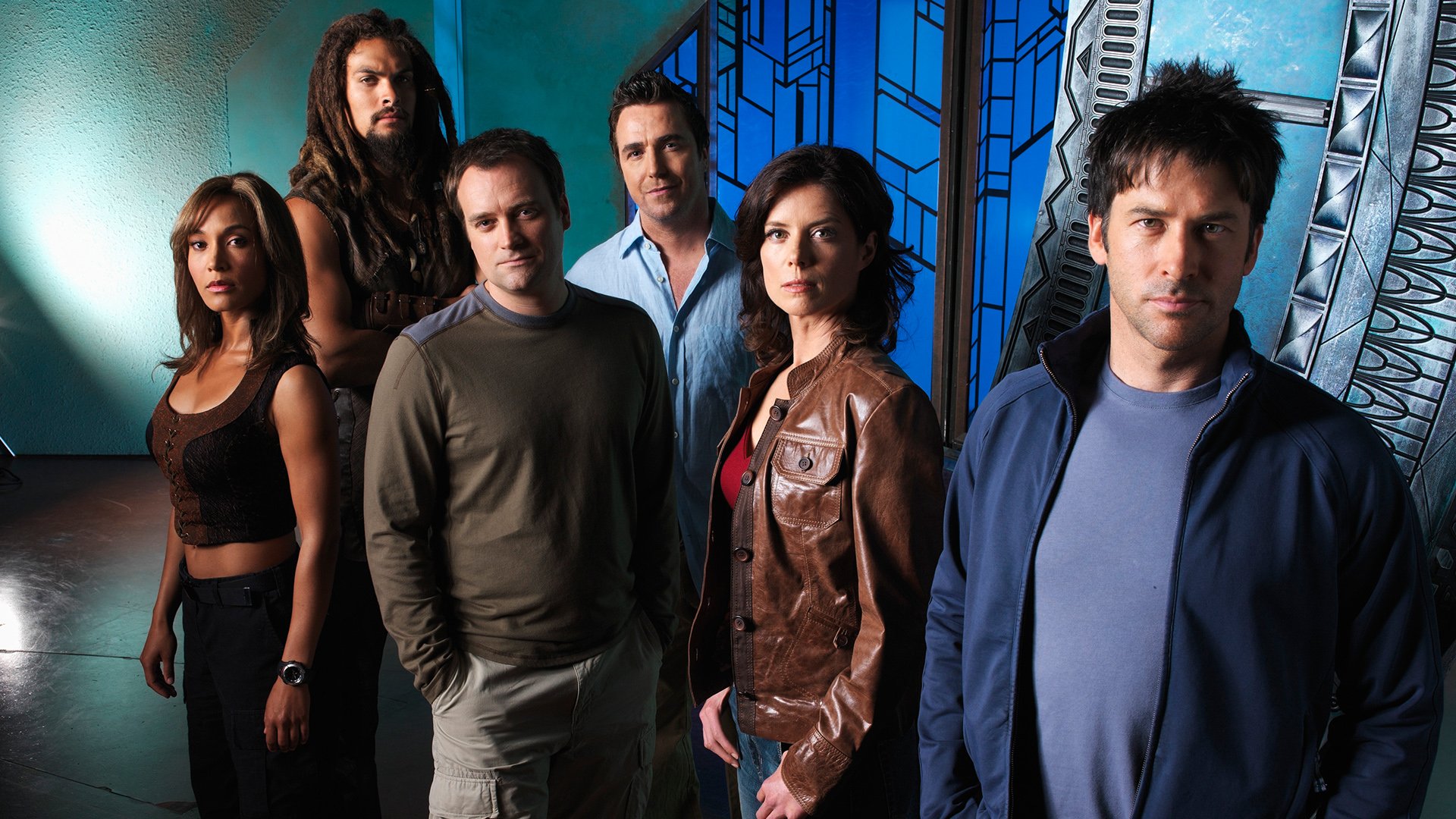 HD desktop wallpaper featuring the main cast of the TV show Stargate Atlantis standing against a futuristic blue-toned background.
