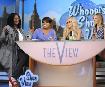 HD desktop wallpaper of 'The View' with hosts smiling behind the show's desk on set.
