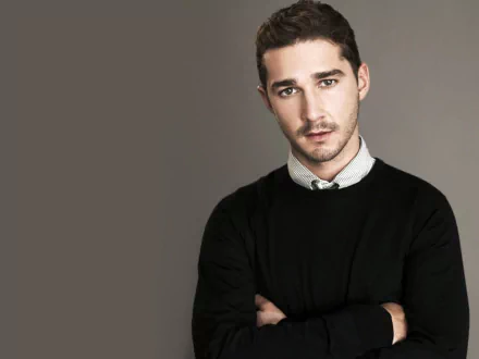 HD desktop wallpaper featuring a portrait of a man in a black sweater and white-collared shirt with a serious expression, set against a gray background.