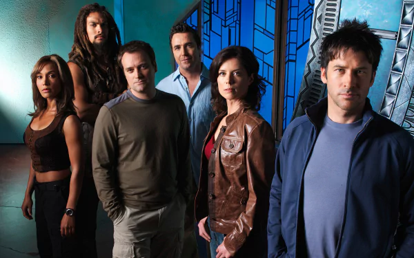 HD desktop wallpaper featuring the main cast of the TV show Stargate Atlantis standing against a futuristic blue-toned background.