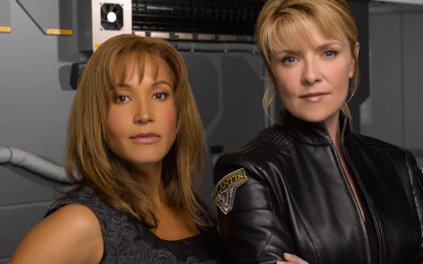 HD desktop wallpaper of two female characters from the TV show Stargate Atlantis posed against a ship-like control room background