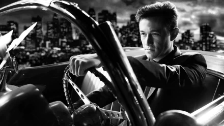 Black-and-white 5K Ultra HD PC desktop wallpaper: a suited man gripping a vintage steering wheel, city skyline behind him — promotional image for the movie Sin City: A Dame to Kill For.