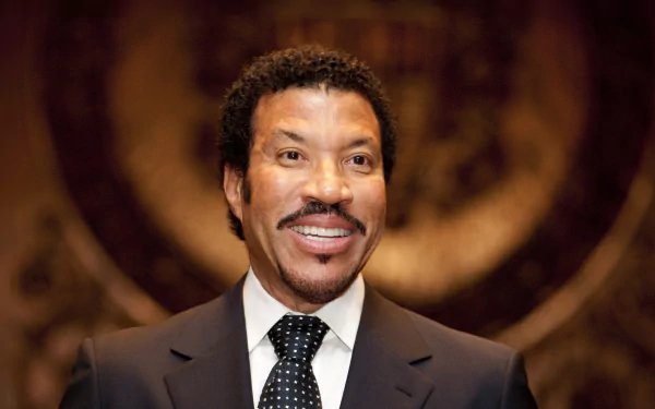 HD desktop wallpaper featuring a smiling man in a suit with an ornate background.