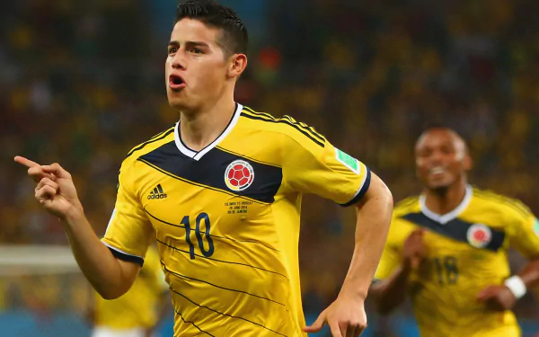 HD wallpaper of a soccer player in yellow Colombia kit in action on the field, energetic background for desktops.