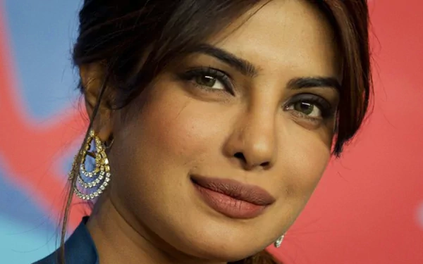 HD desktop wallpaper featuring Indian celebrity Priyanka Chopra, Miss World, with an elegant close-up showcasing her poised expression and statement earrings against a colorful background.