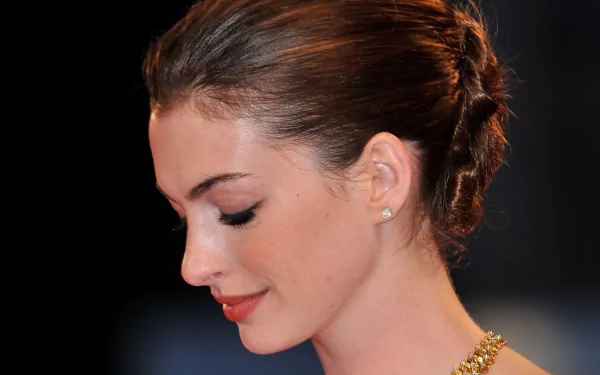 HD PC desktop wallpaper featuring a close-up profile of celebrity Anne Hathaway with elegant makeup and a braided updo against a dark background.
