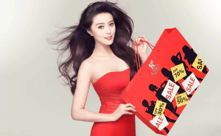 A stylish HD desktop wallpaper featuring Celebrity Fan Bingbing, elegantly dressed in red, holding a vibrant shopping bag adorned with sale promotions.