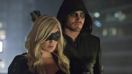 Caity Lotz as Black Canary stands beside Stephen Amell in his iconic hooded costume, capturing a tense moment from the TV show Arrow in this HD wallpaper.