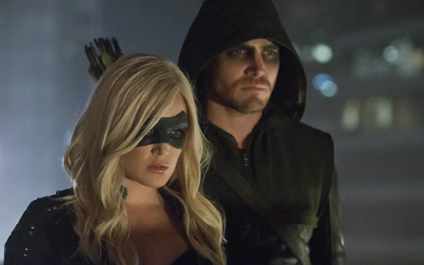 Caity Lotz as Black Canary stands beside Stephen Amell in his iconic hooded costume, capturing a tense moment from the TV show Arrow in this HD wallpaper.