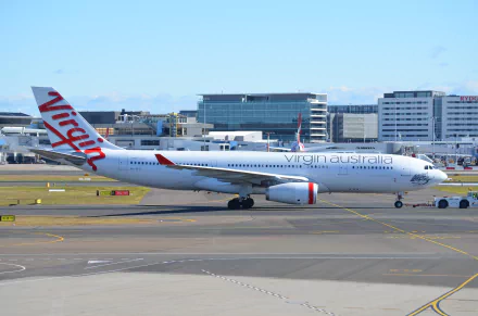 A Virgin Australia Airbus A330 taxiing at Sydney Airport, showcasing the aircraft against a backdrop of modern terminals and vibrant blue skies.