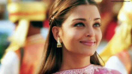 A stunning HD wallpaper featuring Indian celebrity Aishwarya Rai, showcasing her radiant smile and traditional attire against a vibrant background.