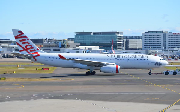 A Virgin Australia Airbus A330 taxiing at Sydney Airport, showcasing the aircraft against a backdrop of modern terminals and vibrant blue skies.