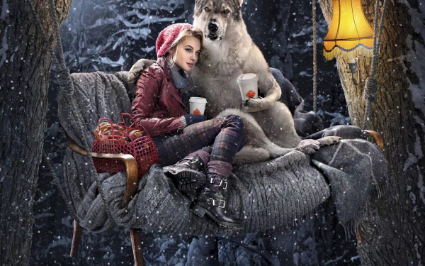 A fantasy scene featuring a woman in a red riding hood, sitting with a wolf on a cozy chair amidst a snowy forest, illuminated by a warm lamp. Perfect HD wallpaper for a desktop background.