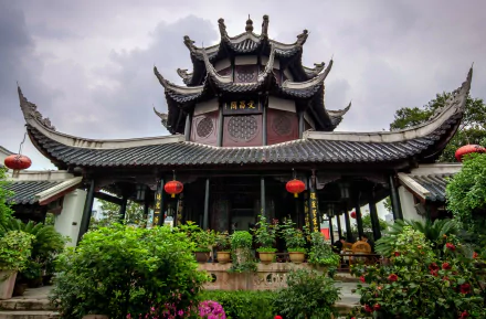 HD desktop wallpaper of a Chinese religious temple: ornate multi-tiered pagoda roof, red lanterns and lush gardens beneath a moody sky.