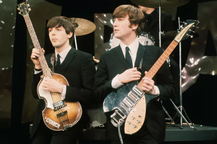 An ultra HD wallpaper featuring members of The Beatles performing, with Paul McCartney on bass and John Lennon holding an electric guitar, capturing the essence of iconic music history.