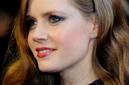 Close-up HD desktop wallpaper of American actress Amy Adams with red hair, blue eyes, and a subtle smile.