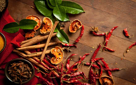 HD PC desktop wallpaper featuring a vibrant display of herbs and spices, including dried chili peppers, star anise, cinnamon sticks, and dried citrus on a wooden surface.