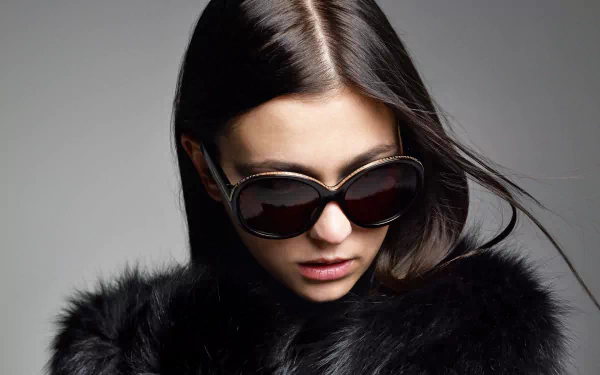 HD desktop wallpaper featuring French model Morgane Dubled wearing oversized sunglasses and a black fur coat against a gray background.