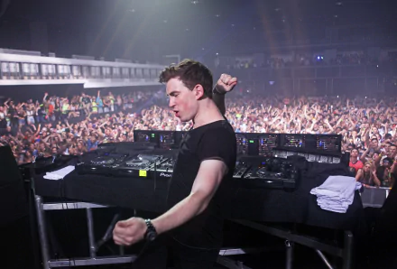 HD PC desktop wallpaper featuring DJ Hardwell performing live, energizing a large crowd at a music event.