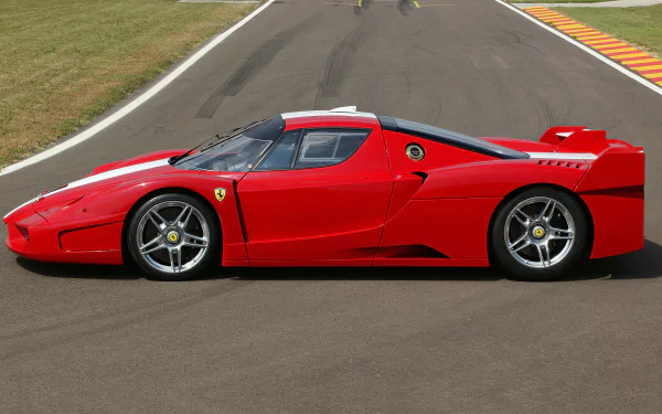 HD desktop wallpaper featuring a vibrant red Ferrari FXX race car parked on a racetrack, showcasing the sleek design and iconic Ferrari emblem.