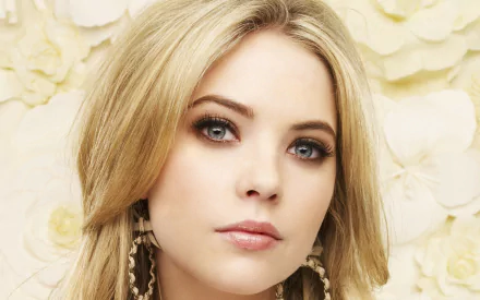 Close-up of celebrity Ashley Benson against a soft floral background. A stunning HD desktop wallpaper capturing her striking features and captivating gaze.
