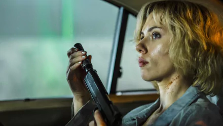 Scarlett Johansson as Lucy holding a weapon inside a car, captured in a detailed 4K Ultra HD movie scene wallpaper.