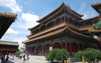HD desktop wallpaper of the Lama Temple in Beijing, China, showcasing traditional religious architecture under a bright blue sky.