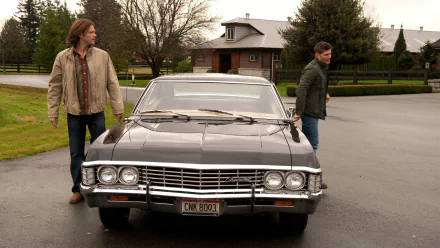 High-definition wallpaper featuring characters from the TV show Supernatural, standing beside a classic car in a tranquil outdoor setting.