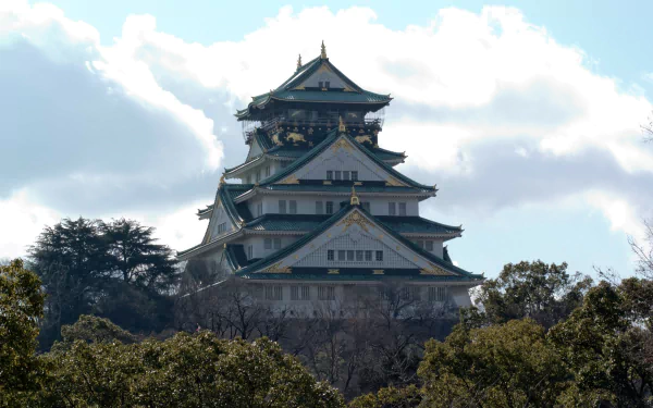 HD desktop wallpaper featuring the iconic man-made Osaka Castle in Japan, framed by greenery under a bright sky.