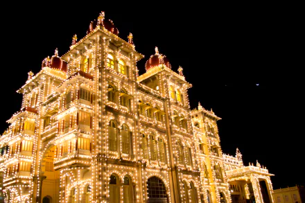 Mysore Palace illuminated at night, showcasing its grand architecture in Karnataka, India. A stunning HD desktop wallpaper capturing the beauty of this man-made landmark.