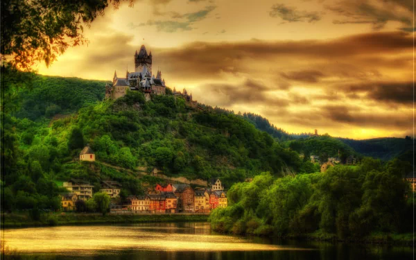 HD PC desktop wallpaper/background of Germany, Kohem: man-made hilltop castle overlooking a riverside village and verdant hills beneath a dramatic golden sky.
