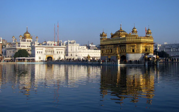 A serene view of the Golden Temple in Amritsar, India, reflecting in the surrounding waters, showcasing the religious significance of this Gurudwara and the Akal Takht.