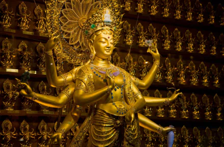 HD wallpaper featuring a golden statue of Goddess Durga, prominent in Hinduism, surrounded by numerous smaller statues, set against a richly adorned background.