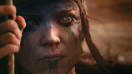Close-up of Senua from Hellblade: Senua's Sacrifice, featuring detailed face paint and intense expression, captured in an HD PC desktop wallpaper.