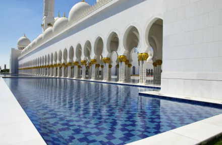 A serene view of the Sheikh Zayed Grand Mosque in Abu Dhabi, reflecting in the tranquil pool, showcasing the mosque's stunning architecture and religious significance in the UAE.