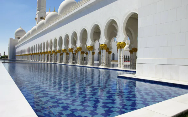 A serene view of the Sheikh Zayed Grand Mosque in Abu Dhabi, reflecting in the tranquil pool, showcasing the mosque's stunning architecture and religious significance in the UAE.