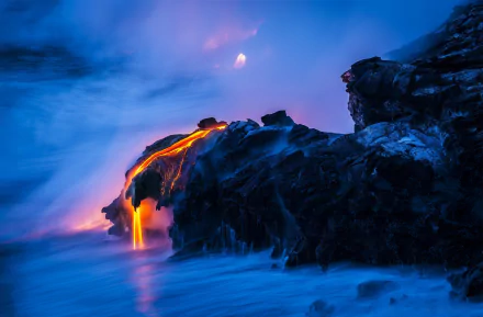 A captivating HD desktop wallpaper of glowing lava cascading over dark volcanic rock, set against a misty blue backdrop, showcasing the raw beauty of nature and volcanic activity.
