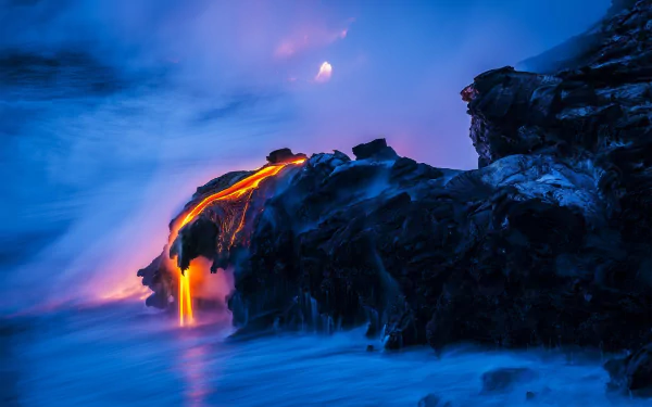A captivating HD desktop wallpaper of glowing lava cascading over dark volcanic rock, set against a misty blue backdrop, showcasing the raw beauty of nature and volcanic activity.