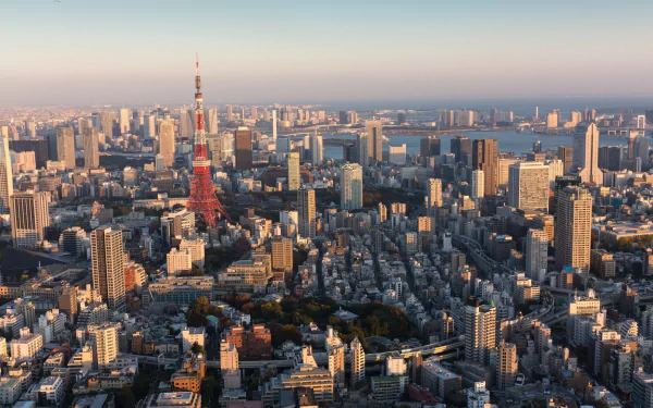A stunning HD desktop wallpaper featuring Tokyo Tower standing tall amid Tokyo’s urban skyline at sunset in Japan.