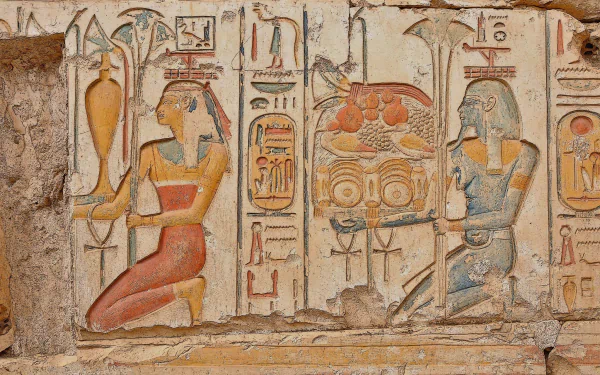 HD desktop wallpaper of ancient Egyptian man-made carvings depicting figures and hieroglyphs in vibrant colors on an old stone wall.