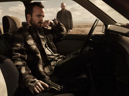 2K Quad HD Breaking Bad desktop wallpaper: tense desert scene with a man seated in a car holding a gun and another standing nearby, gritty cinematic lighting.
